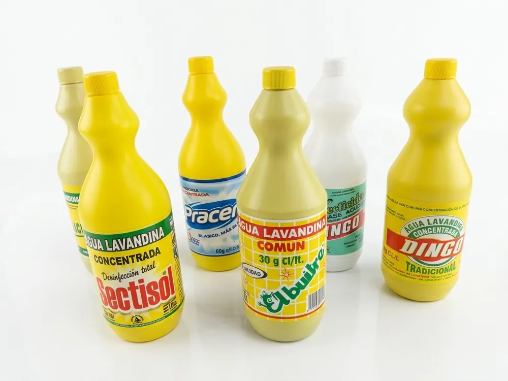 Botellas de lavandina con fajas y etiquetas impresas
